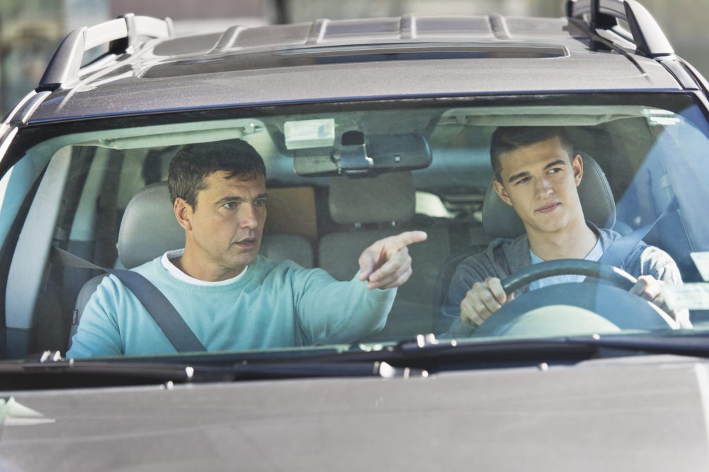 USA, New Jersey, Jersey City, Father with teenage (16-17) son driving.