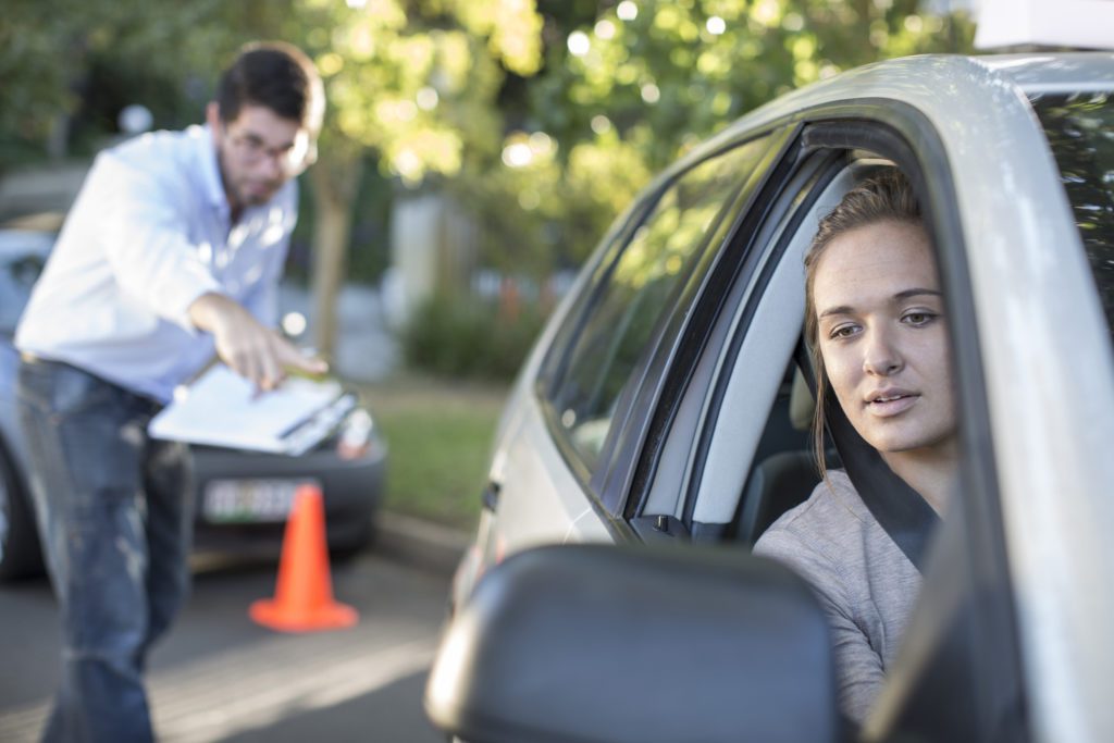 Young woman in a car with driving instructor.